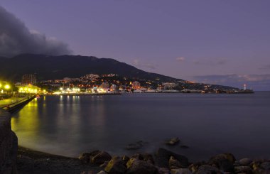 Akşam setin Yalta dağlar ve bulutlu gün batımı gökyüzü arka plan üzerinde Karadeniz kıyısında. Crimea. Ukrayna