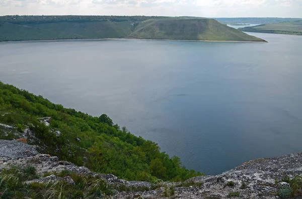 Yüksek sarp tepeler arasında büyük nehir Dniester akışı mavi gökyüzüne karşı bahar gür yeşil çim kaplı. Ukrayna