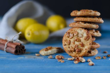 Renkli şekerlenmiş meyve ve sulu turuncu tahta bir masanın üzerinde yatan bir dilim ile yuvarlak portakal bisküvi. Portre