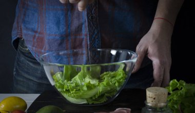 Adam marul, yeşil salata hazırlanıyor. Sağlıklı gıda kavramı