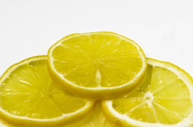 İnce dilimlenmiş limon dilimleri yalan beyaz bir arka plan üzerine