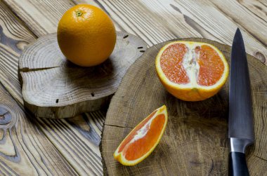 Sicilya portakal ve bıçak ile bir ahşap masa, ahşap bir masa üzerinde duran siyah topuzu dayanmaktadır