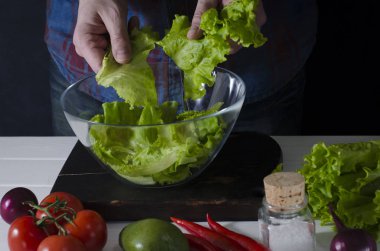 Adam marul, yeşil salata hazırlanıyor. Sağlıklı gıda kavramı