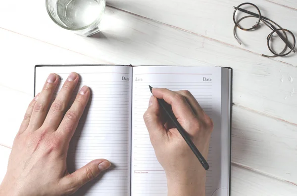 L'uomo passa note di scrittura al notebook su tavolo di legno in ufficio familiare — Foto Stock