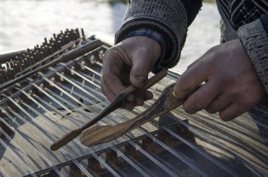 Eski sokak müzisyeni eski bir enstrüman üzerinde oynanan eller kirli