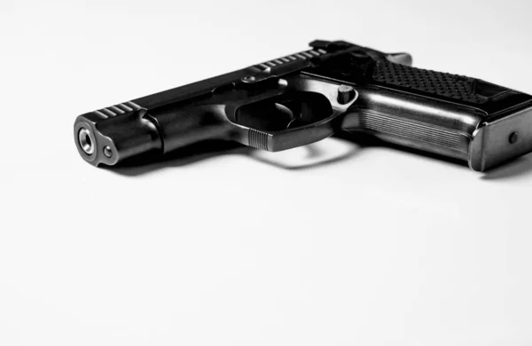 Pistola de metal preto está em um fundo branco, close-up — Fotografia de Stock