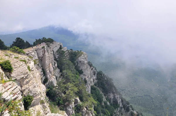 Picos de montanha de montanhas da Crimeia coberto com névoa em um fundo de céu azul e mar — Fotografia de Stock