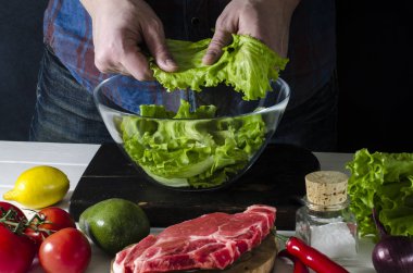 Adam marul, yeşil salata hazırlanıyor. Sağlıklı gıda kavramı
