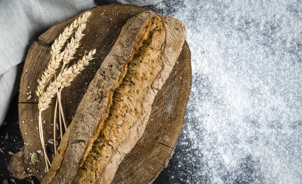 Vers gebakken zelfgebakken traditioneel brood op rustieke houten tafel — Stockfoto