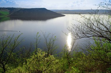 Büyük nehir Dinyester mavi gökyüzüne karşı bahar gür yeşil çimen ile kaplı yüksek dik tepeler arasında akar