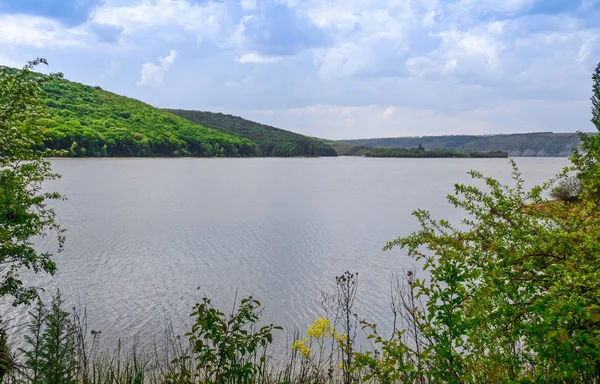 D'énormes falaises abruptes en pierre sur le fond d'une rivière Dniester et un ciel bleu avec des nuages — Photo