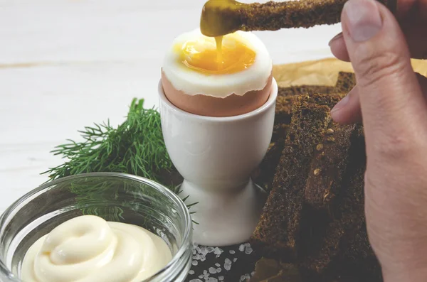 Healthy food. English breakfast with boiled egg and croutons on a white wood background