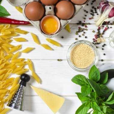 Penne makarna, Yeşil fesleğen, parmesan, susam, sarımsak, Chilli, yumurta beyaz bir ağaç masada yalan