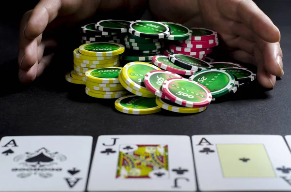 Poker oynayan ve kartlara bakan kişi