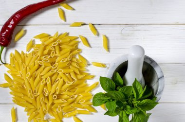 Penne makarna, Yeşil fesleğen, parmesan, susam, sarımsak, Chilli, yumurta beyaz bir ağaç masada yalan