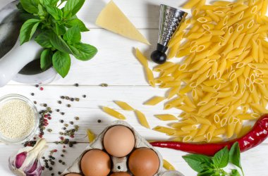 Penne makarna, Yeşil fesleğen, parmesan, susam, sarımsak, Chilli, yumurta beyaz bir ağaç masada yalan