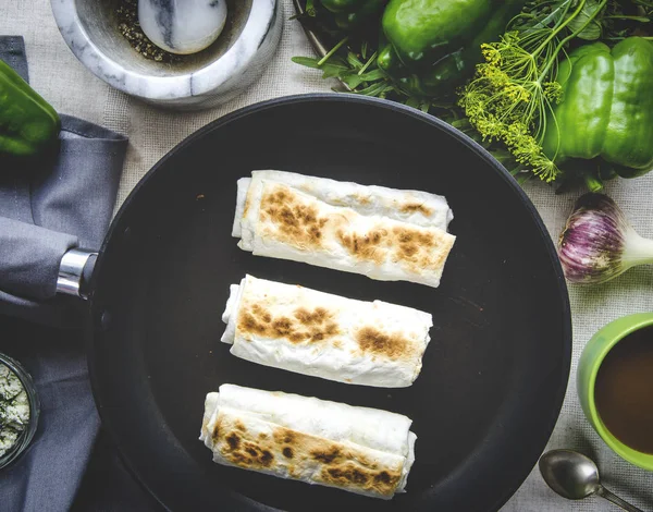 건강 한 아침 식사. 녹색 채소. 치즈와 딜을 곁들인 피타 빵이 야채와 커피 한잔 옆에 있는 둥근 회색 접시 위에 놓여 있다 — 스톡 사진