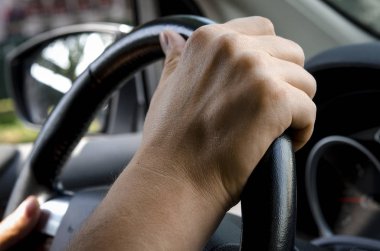 Arabanın direksiyonunu tutan bir adamın ellerini yakından kapatın. Otomatik