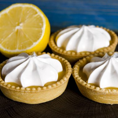 Ahşap bir masada limon dolgulu ve limonlu beyaz hava keki