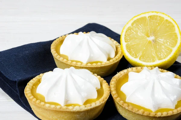 White aircake with lemon filling and lemon on a wooden table