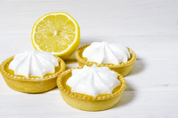 White aircake with lemon filling and lemon on a wooden table