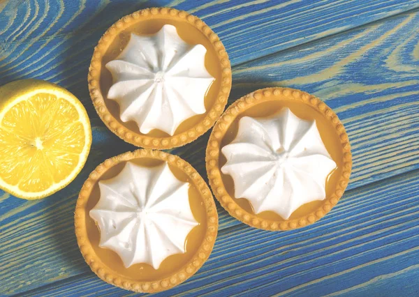 Ahşap bir masada limon dolgulu ve limonlu beyaz hava keki