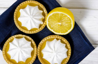 Ahşap bir masada limon dolgulu ve limonlu beyaz hava keki