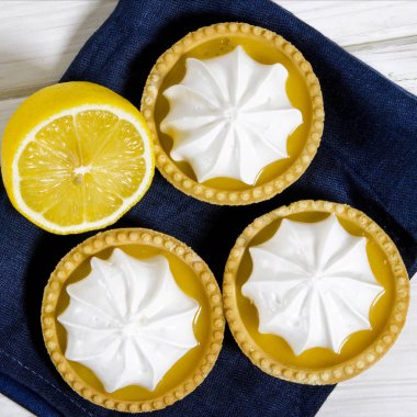 Ahşap bir masada limon dolgulu ve limonlu beyaz hava keki