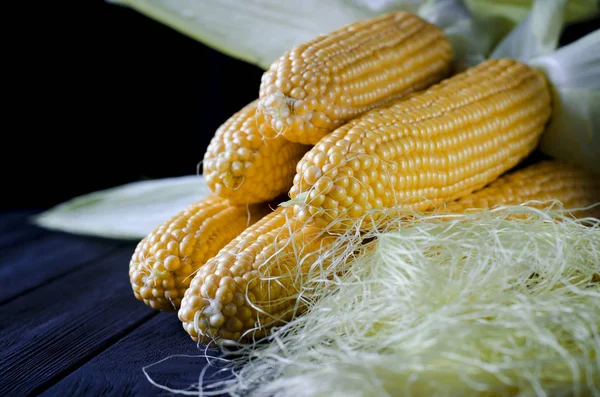 Yeşil yaprakları ile taze sulu sarı mısır bonduel ahşap masa üzerinde yatıyor