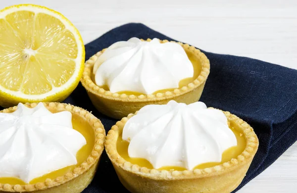 White aircake with lemon filling and lemon on a wooden table