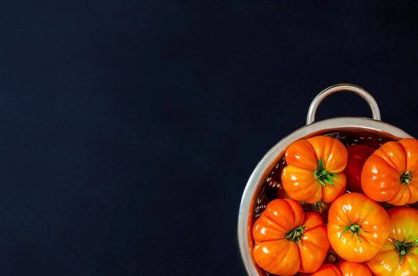 stock image Washed various tomatoes in a colander on a black background