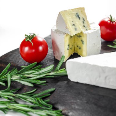 Tahta tahtada çeşitli peynirler. Camembert peyniri, küflü peynir, domatesli mozzarella.