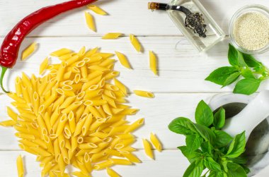 Penne makarna, Yeşil fesleğen, parmesan, susam, sarımsak, Chilli, yumurta beyaz bir ağaç masada yalan