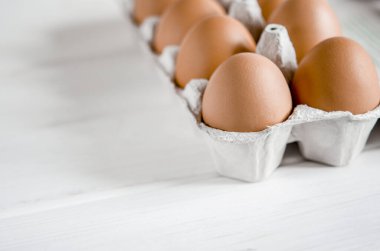 Çevre dostu karton yumurta tepsisinin içinde büyük kahverengi tavuk yumurtaları var.