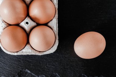 Çevre dostu karton yumurta tepsisinin içinde büyük kahverengi tavuk yumurtaları var.