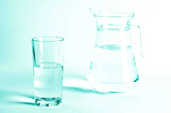 Glass with clean clear water and shadows on a white background