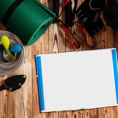 Seyahat içeriği. Sırt çantası, avlu, İskandinav yürüyüşü için sopalar ve turist gereçleri tahta bir arka planda duruyor.