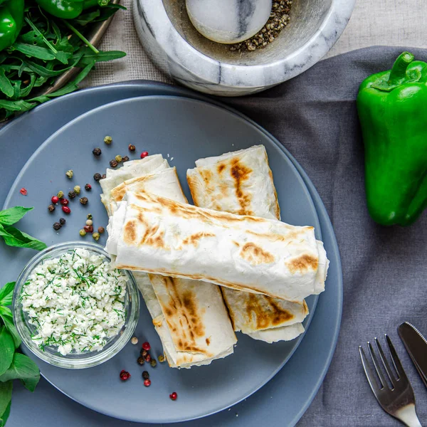 Sağlıklı yiyecekler. Sağlıklı kahvaltı. Yeşil sebze. Peynirli ve dereotlu Pita ekmeği, yeşil tabaklar ve bir fincan kahvenin yanında yuvarlak gri tabaklar üzerine uzanır.