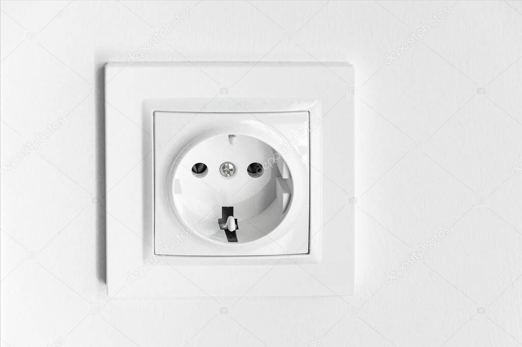 The white plastic socket is mounted in a white wall