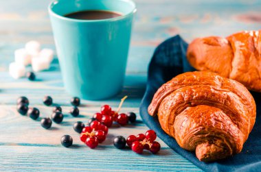 Klasik Fransız kahvaltısı, yanında kruvasan ve kahve.