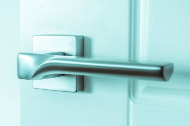 Gümüş metal kapı tokmağı beyaz ahşap bir kapıya monte edilmiştir. Onarım