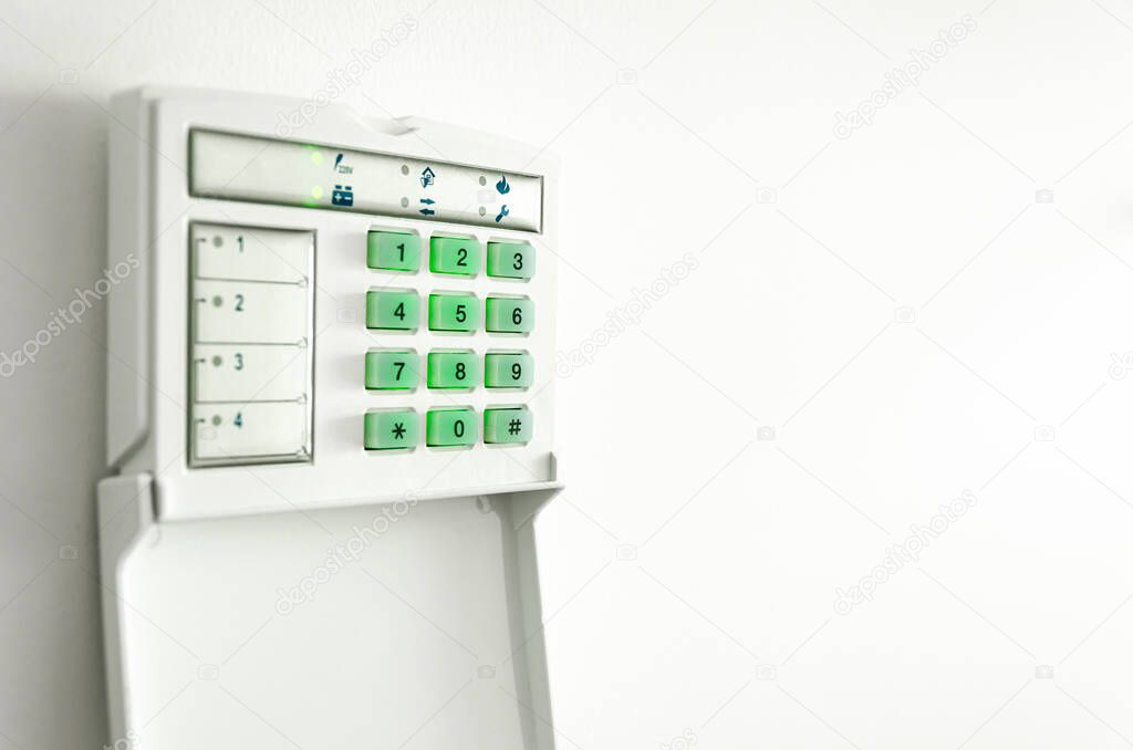 Electronic control panel of the apartment and office security alarm system with electronic keypad on a white wall. Safety. Security service