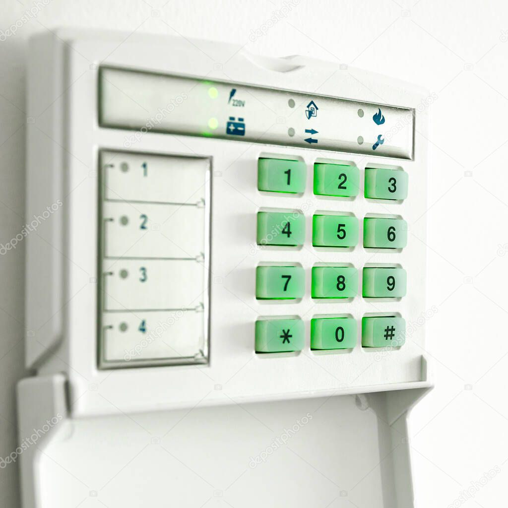 Electronic control panel of the apartment and office security alarm system with electronic keypad on a white wall. Safety. Security service