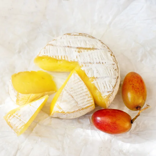 Fromage Camembert à pâte molle et raisins sur fond blanc — Photo