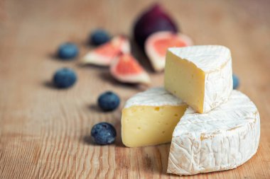 incir ve üzerinde yaban mersini koyu arka plan üzerinde camembert peyniri.