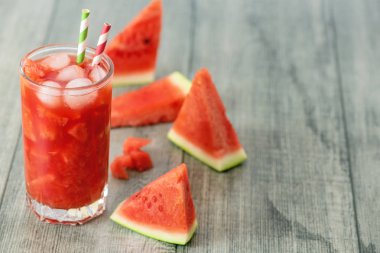 Karpuz kavanoz gri ahşap zemin üzerine taze karpuz dilimleri ile güler yüzlü. Kopya alanı.