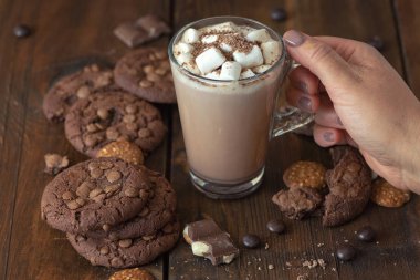 Fincan kakao marshmallows ve koyu ahşap zemin üzerine çikolatalı kurabiye.