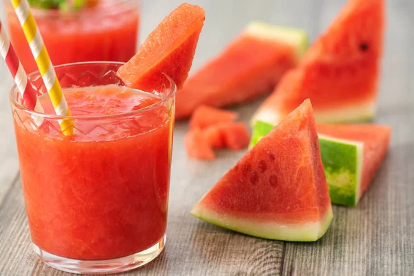 Karpuz yüzlü kavanoz gri ahşap zemin üzerine taze karpuz dilimleri ile.