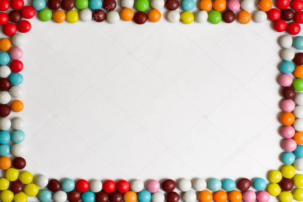 Round chocolate Bonbons covered with colored glaze on white background. Top view