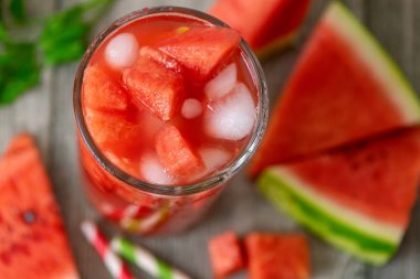 Karpuz kavanoz gri ahşap zemin üzerine taze karpuz dilimleri ile güler yüzlü. Üstten görünüm.